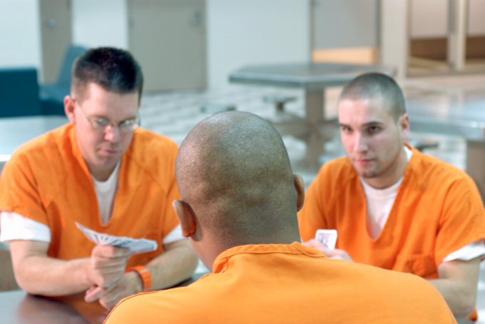 three prison inmates wearing orange jumpsuits