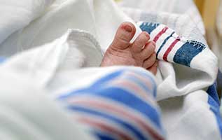 closeup of infant's toes sticking up from blanket